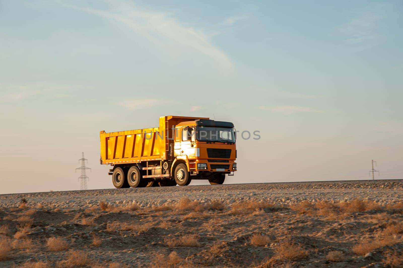 An orange dumper truck in an construction area