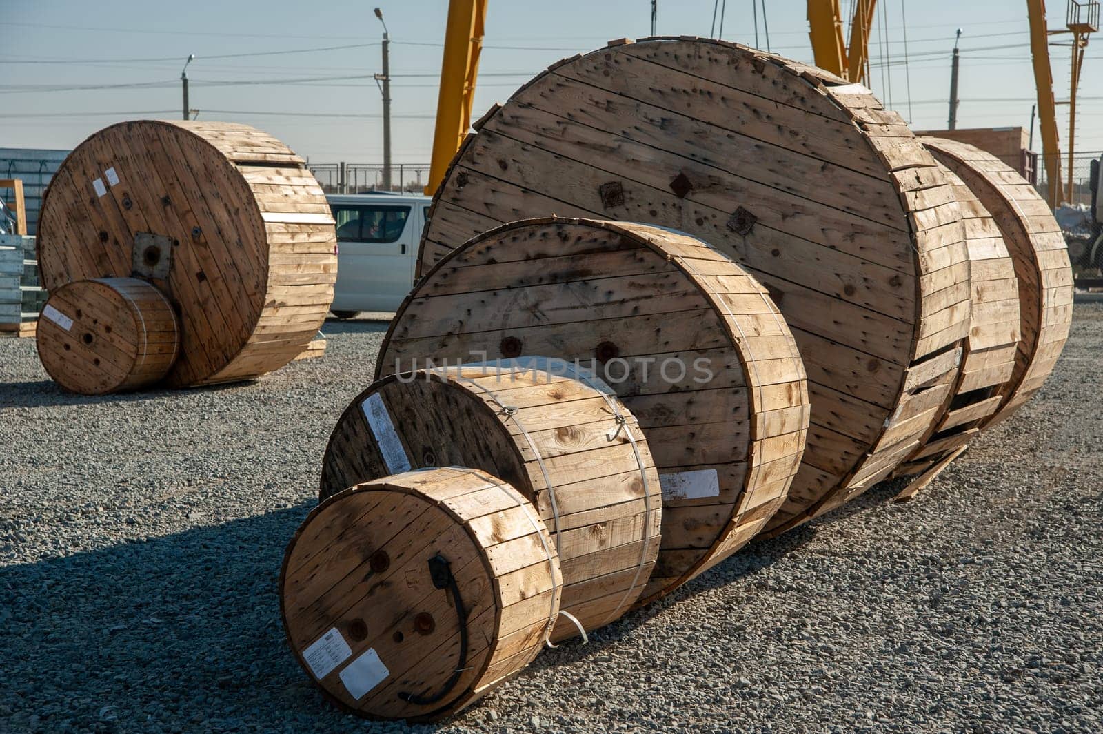 A closeup of large industrial wooden bobbins with cable on a construction site