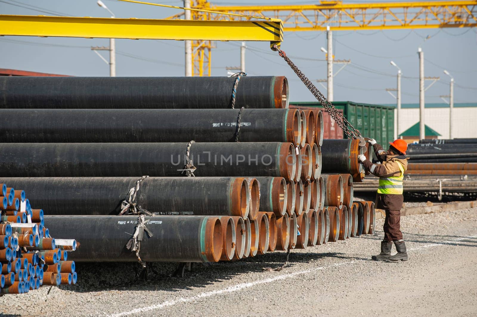 A line of oilfield large streel pipes in industrial construction area by A_Karim