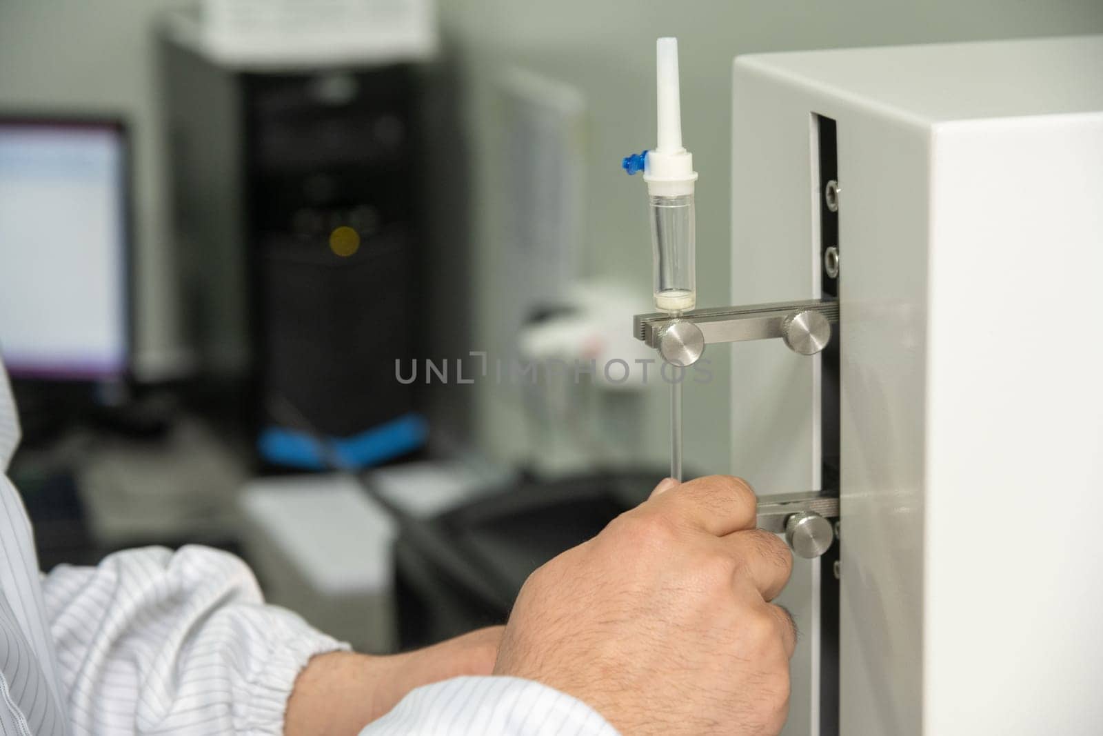 A closeup shot of hands working on a machine in a medical production warehouse for syringes