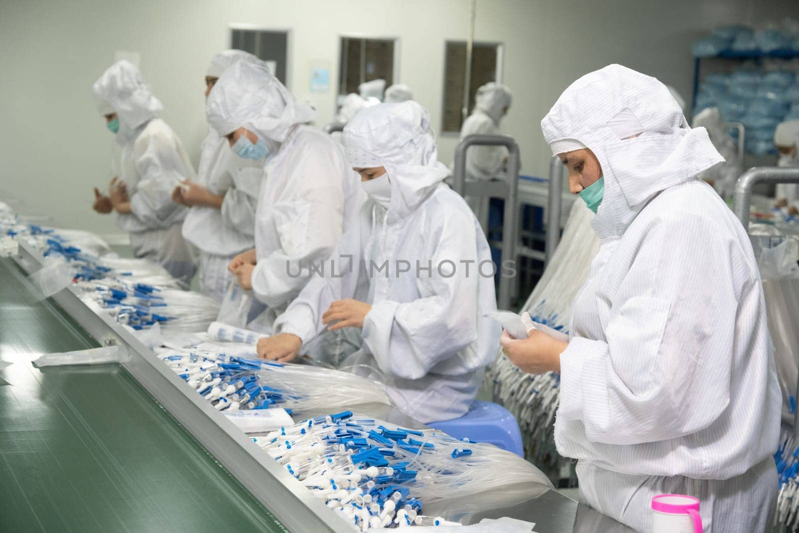 The workers in the workshop for the production of medical syringes and droppers