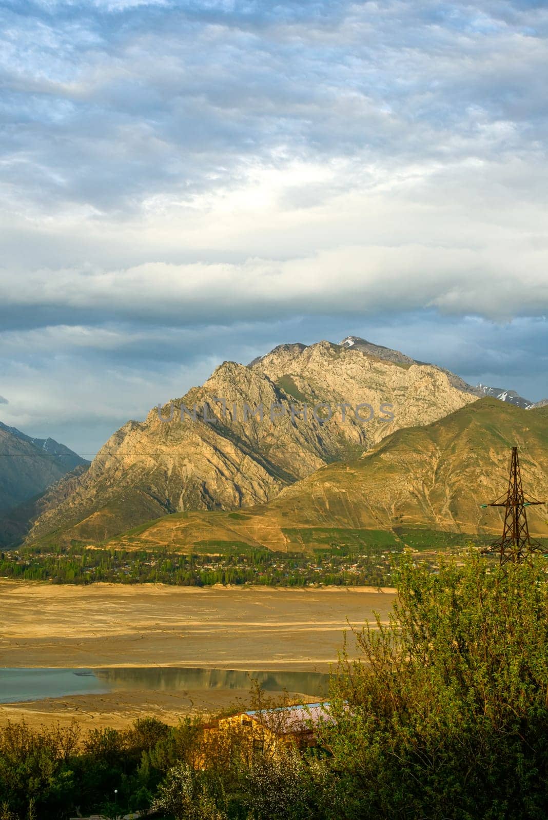 A vertical shot of mountains against the background of the cloudy sky. Central Asia