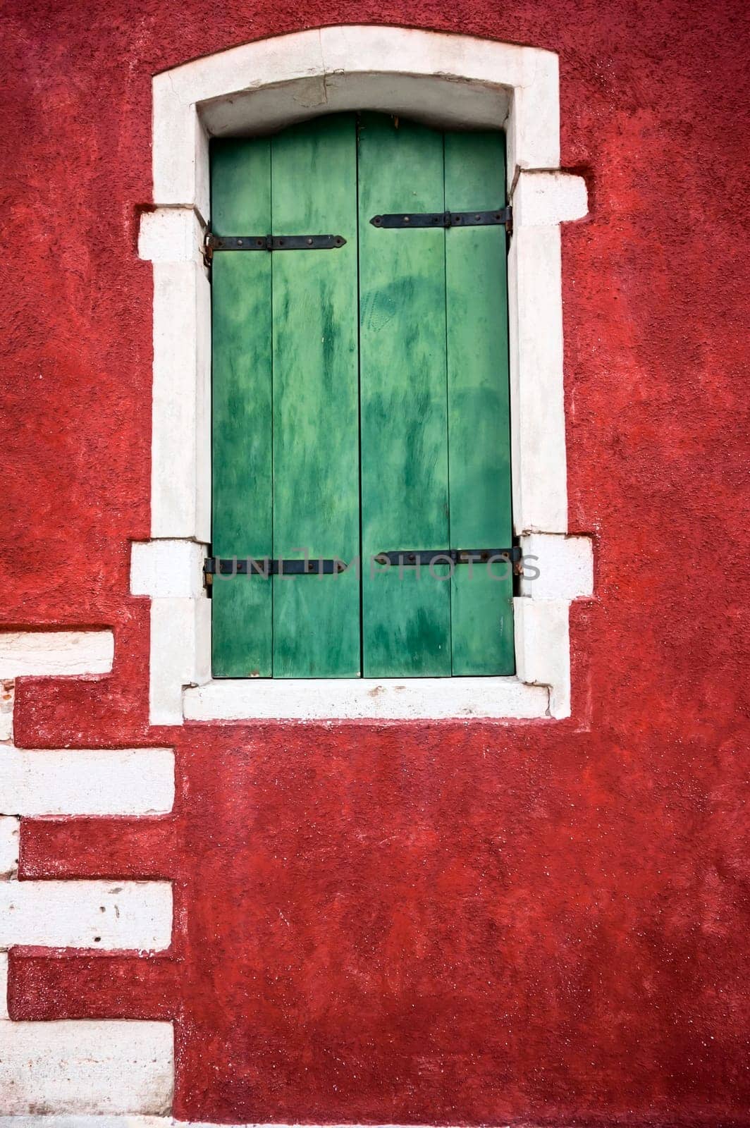 green window on red wall with white and black details