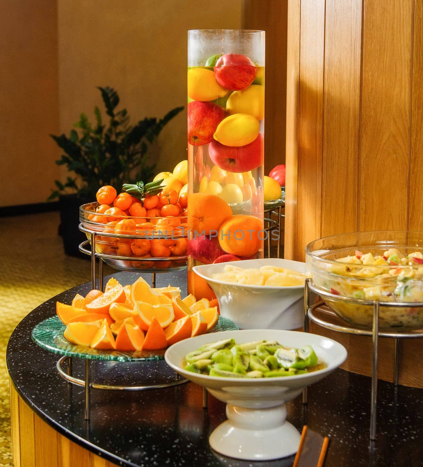 A vertical shot of a buffet table with fruit bowls for product exhibition