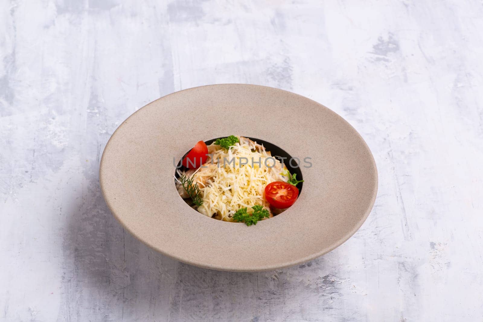 A dish in a beautiful bowl with parmesan on top isolated on a grey background by A_Karim