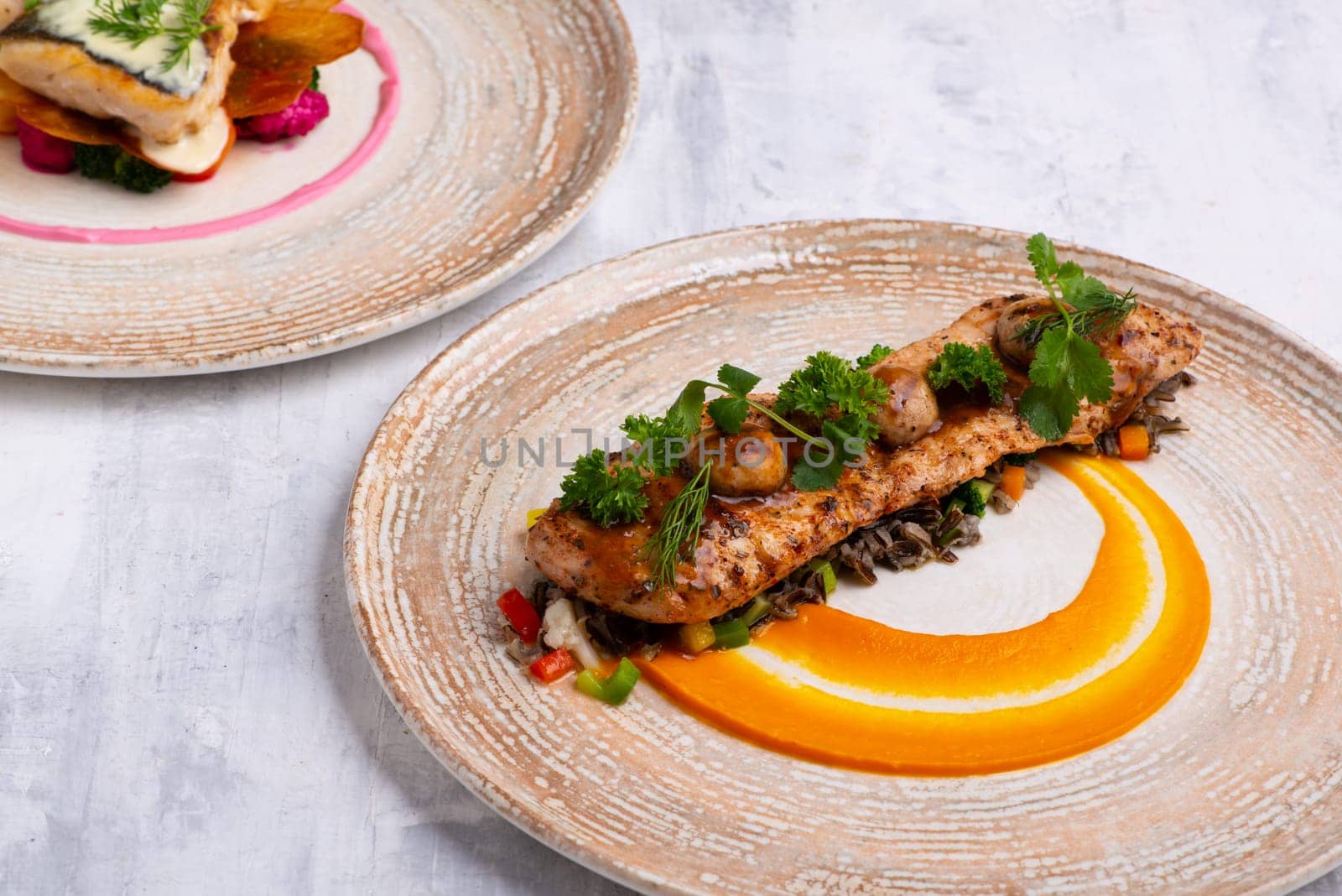 A closeup of beautiful and tasty food on plates isolated on a grey background