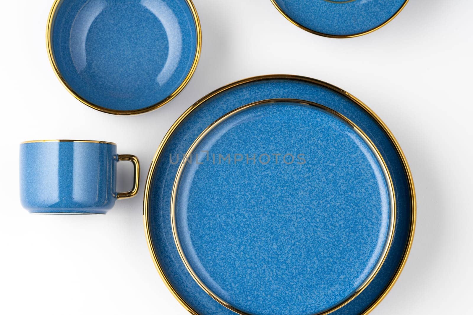 A set of blue ceramic plates and cup on a white background. Top view