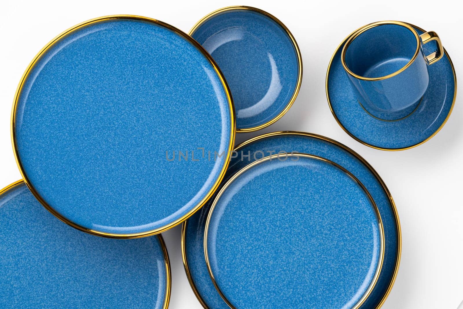 A set of blue ceramic plates and cup on a white background. Top view