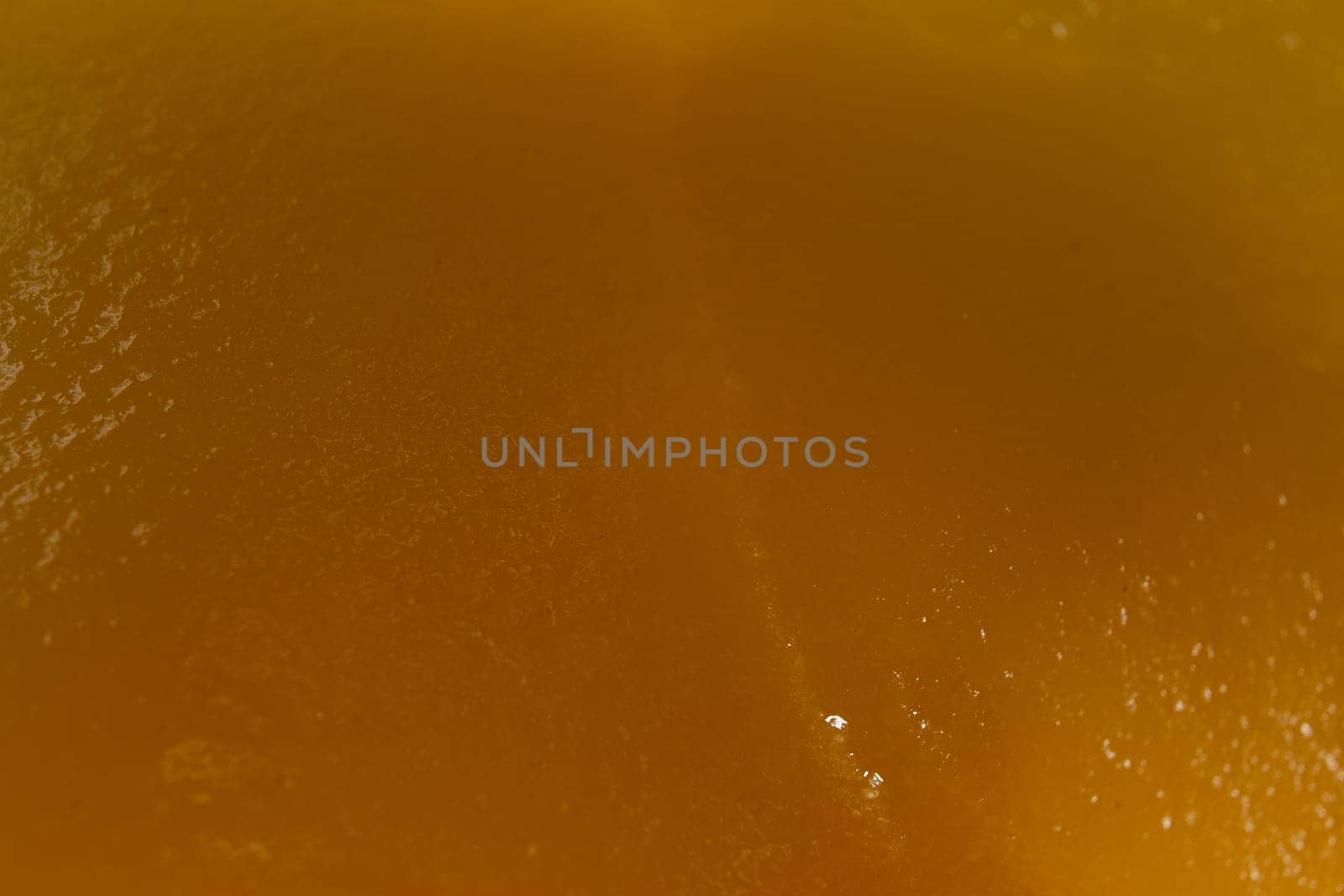 Honey orange textured background, close-up macro view by clusterx