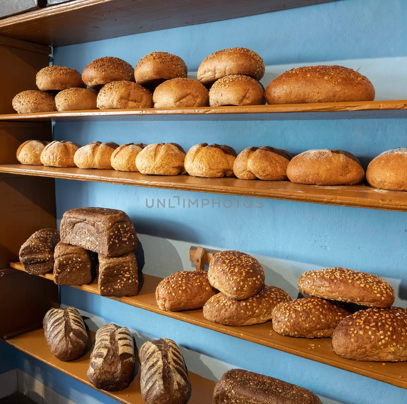 types of bread on the shelves in the bakery such as white bread, brown bread and wholemeal bread