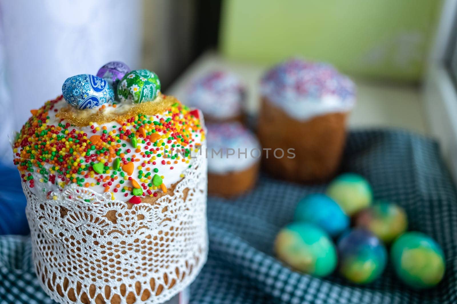 Easter cake with glace icing decoration and colored easter eggs on a holiday table