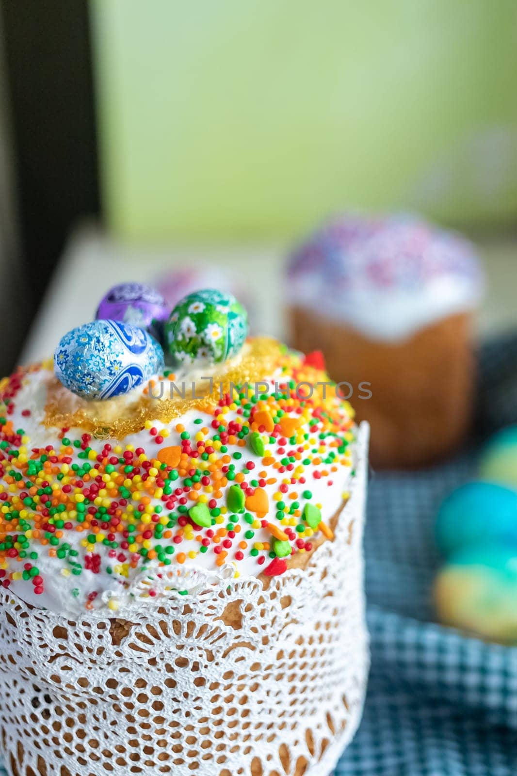 Traditional Easter cake with glace icing and Easter eggs on wooden background with willow twigs. Spring season. Orthodox Easter. Close up, selective focus