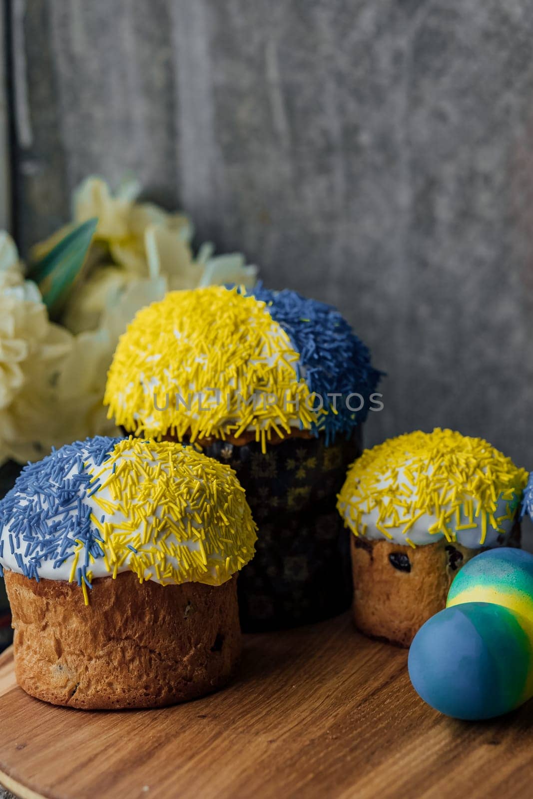 Delicious Easter cakes on a wooden table with flowers in the background. place for text. selective focus