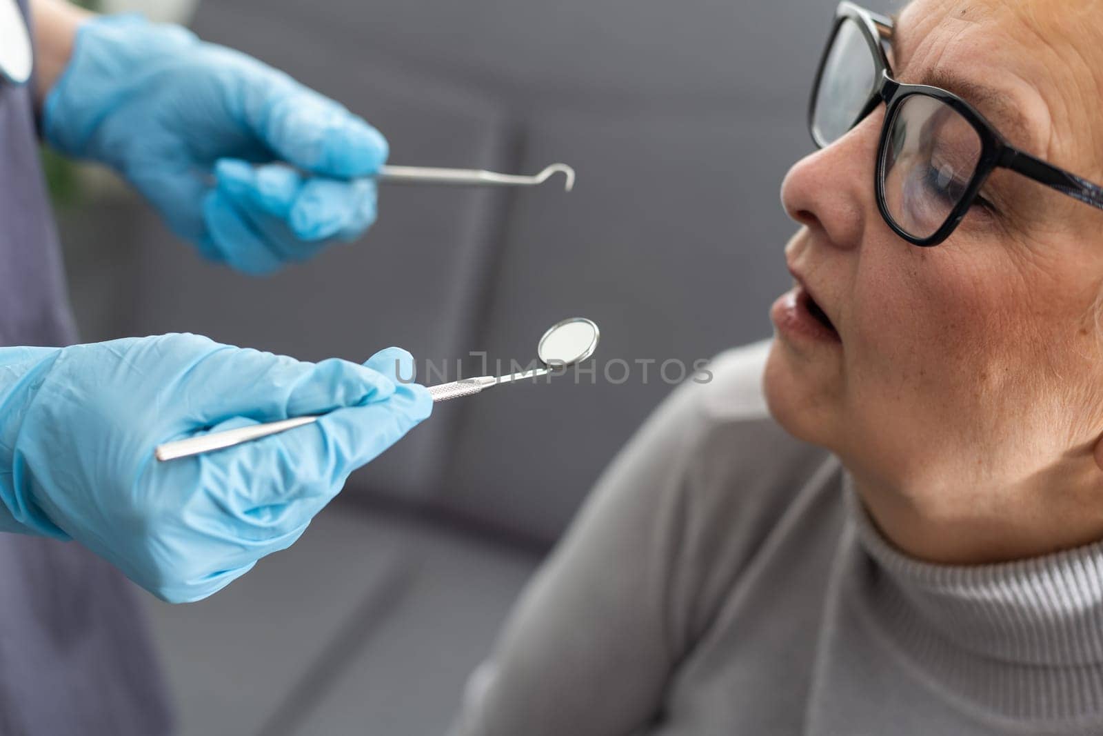 Close up portrait of elderly beautiful woman check up and having the consultation with dentist at the dental office