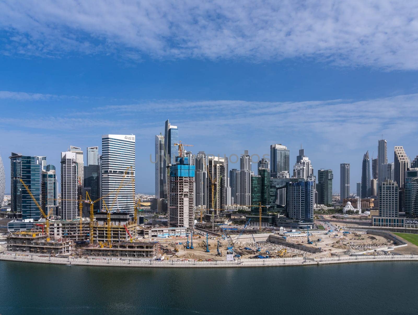 Dubai, UAE - April 1, 2023: Construction of new tower for apartments along canal in Business Bay