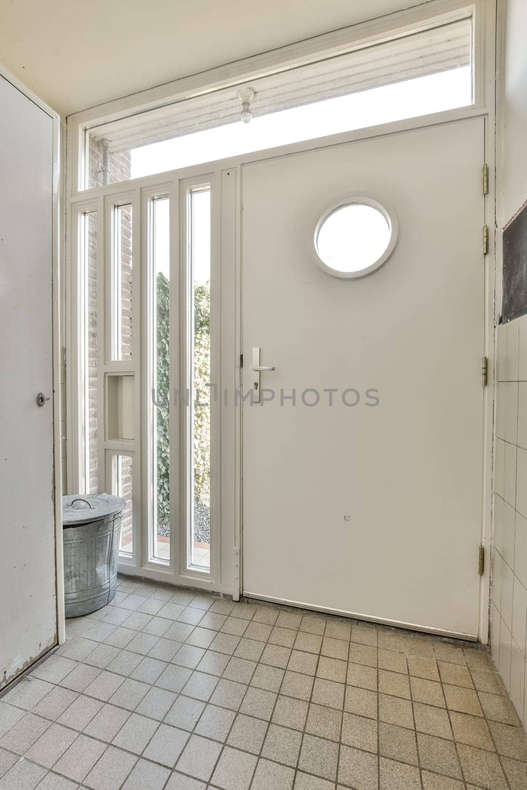 a large white door with a round window and a by casamedia
