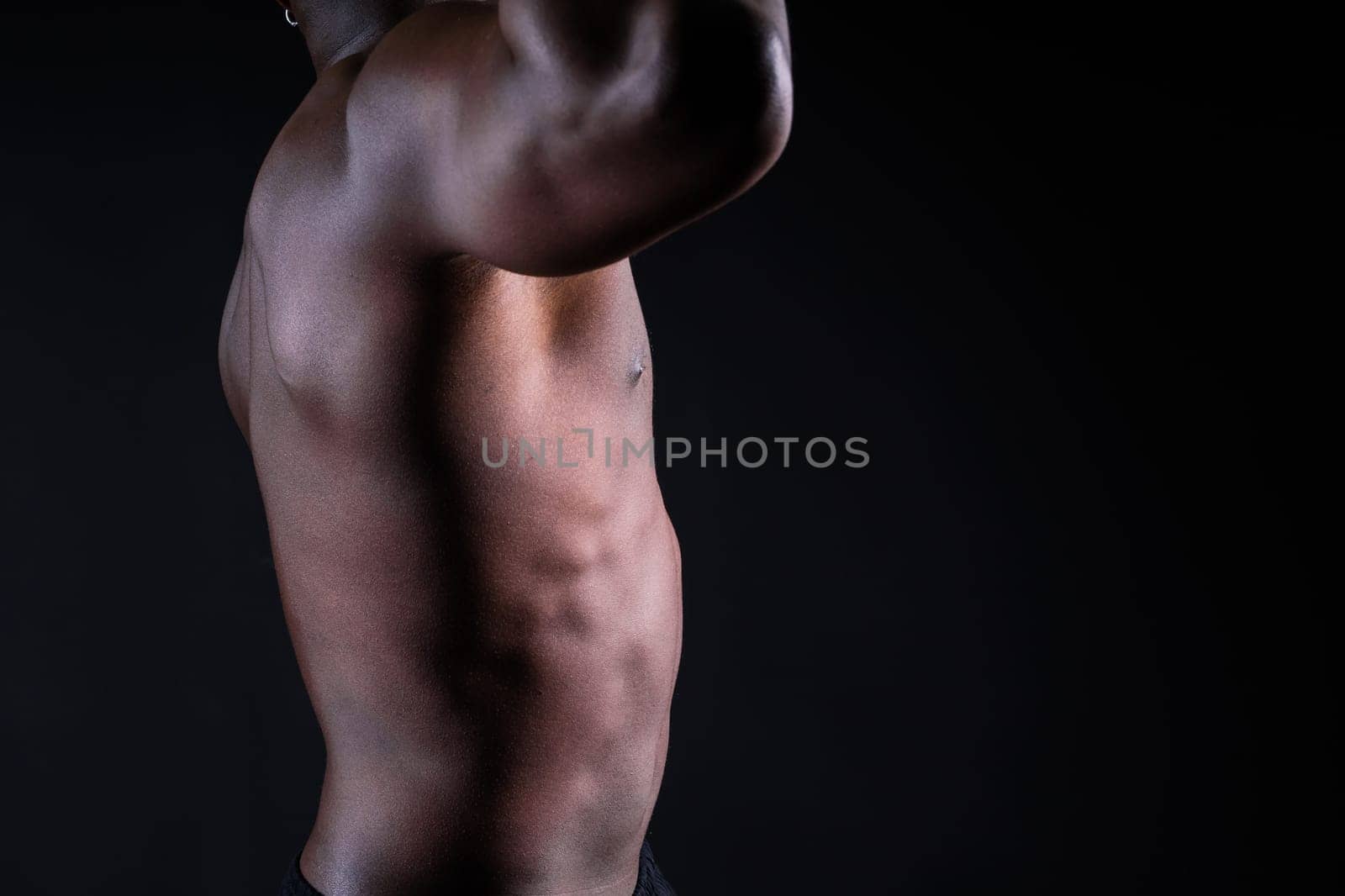 Isolated african muscular man with dumbbells on dark studio background. Strong shirtless black guy by Zelenin