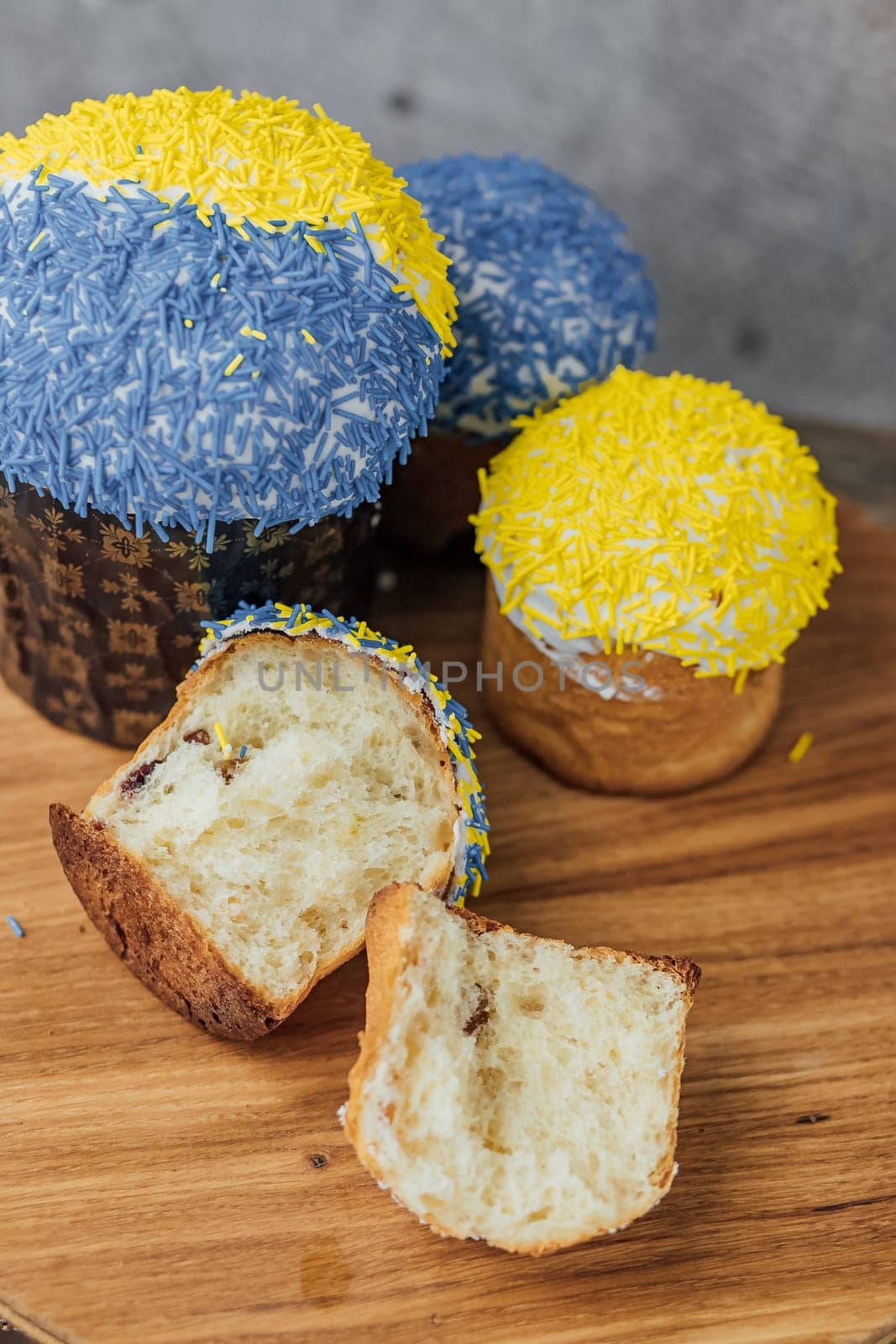 Easter cake is decorated with yellow-blue sprinkles on a gray background. place for text. patriotic paska in the color of the flag of Ukraine.