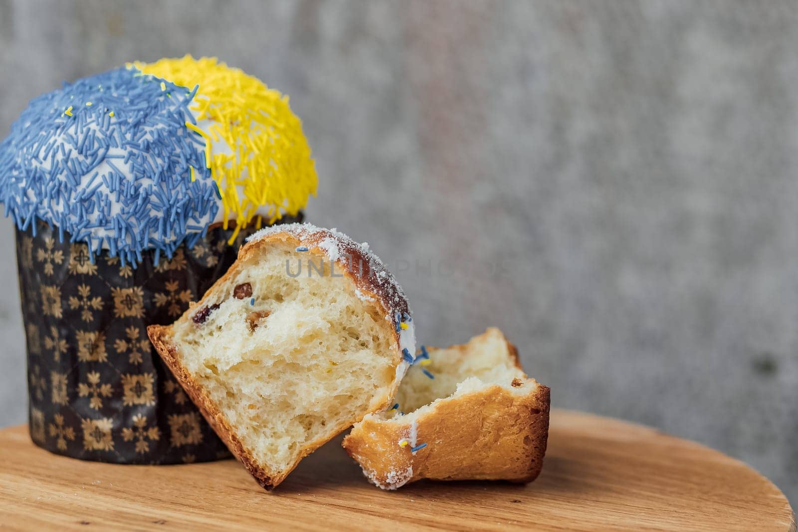 Easter cake is decorated with yellow-blue sprinkles on a gray background. place for text. patriotic paska in the color of the flag of Ukraine.