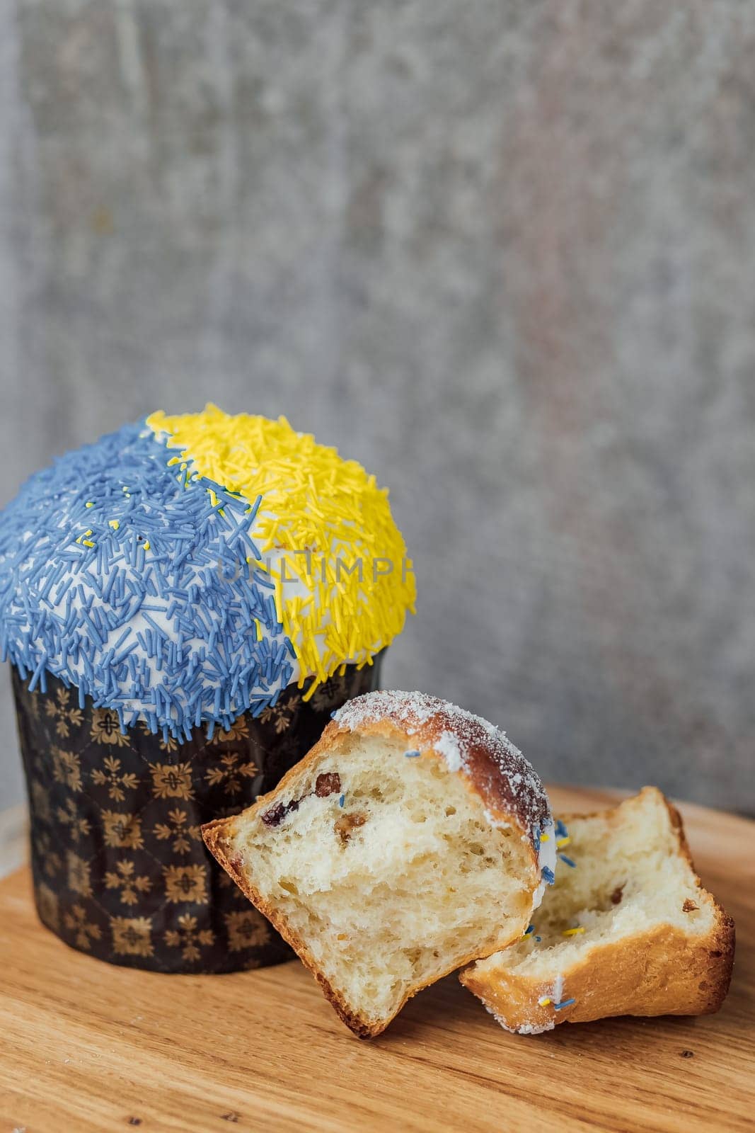 Easter cake is decorated with yellow-blue sprinkles on a gray background. place for text. patriotic paska in the color of the flag of Ukraine.