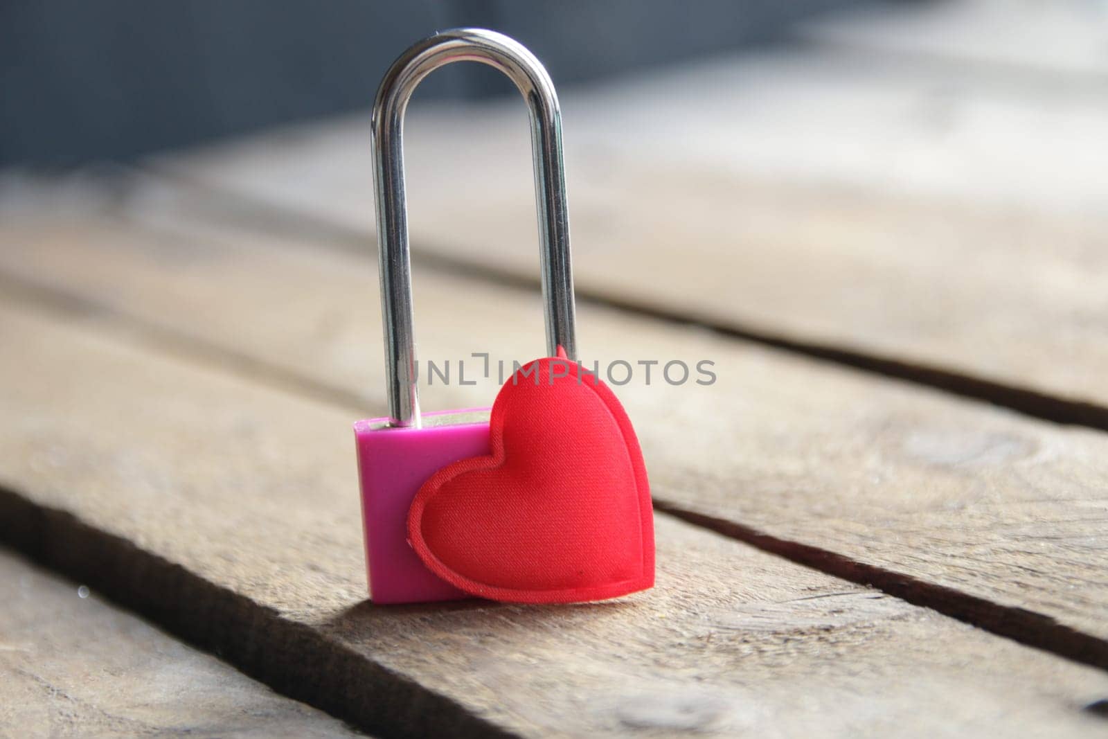 Padlock with a heart on a vintage wooden background.