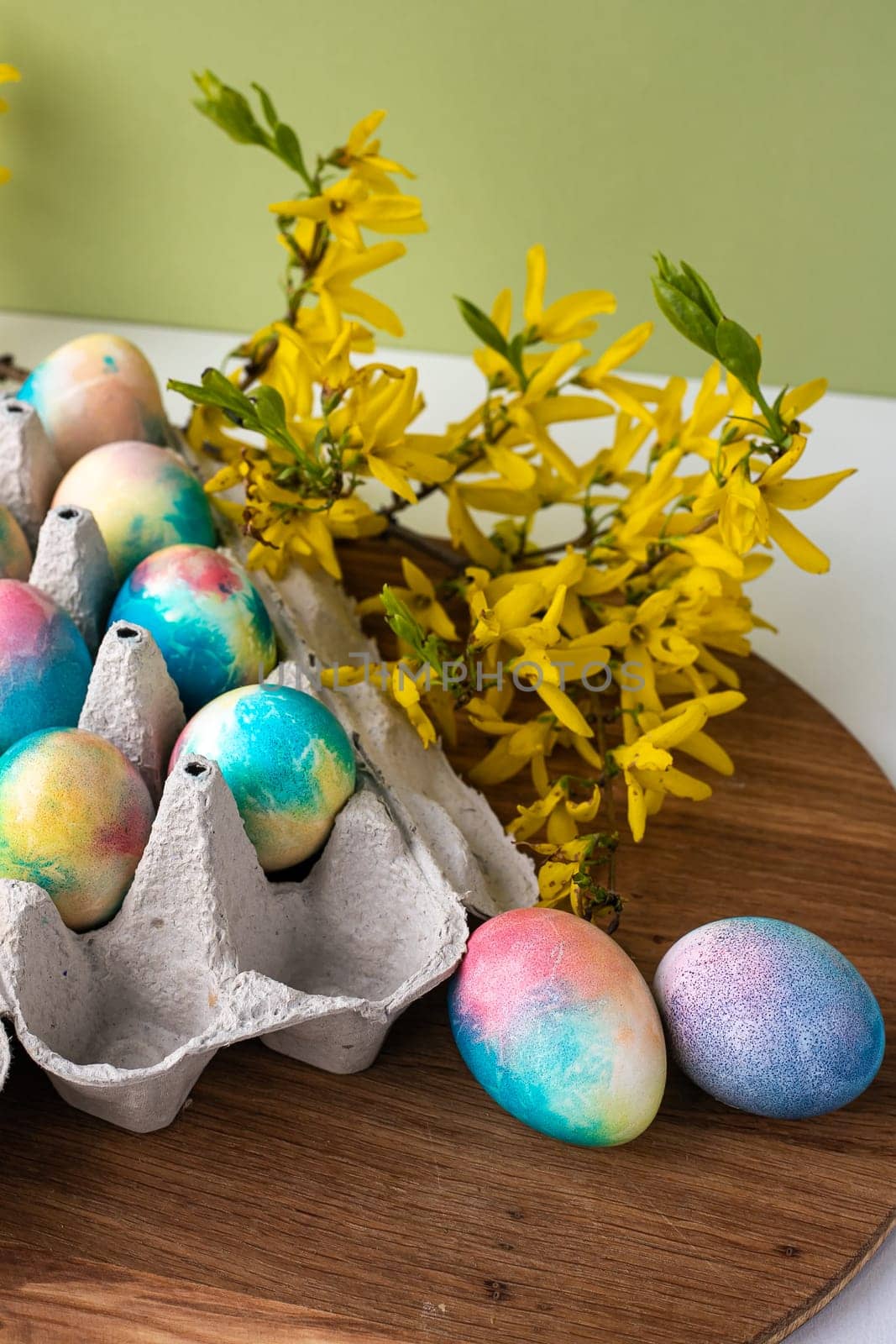 multi-colored Easter eggs on a wooden background, a green background next to yellow flowers by Anyatachka