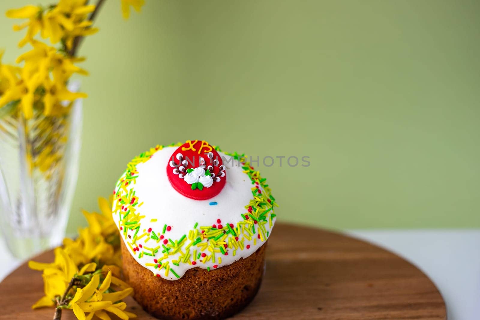 Easter composition with Easter cakes, wooden stand and spring flowers on a yellow background. copy space by Anyatachka