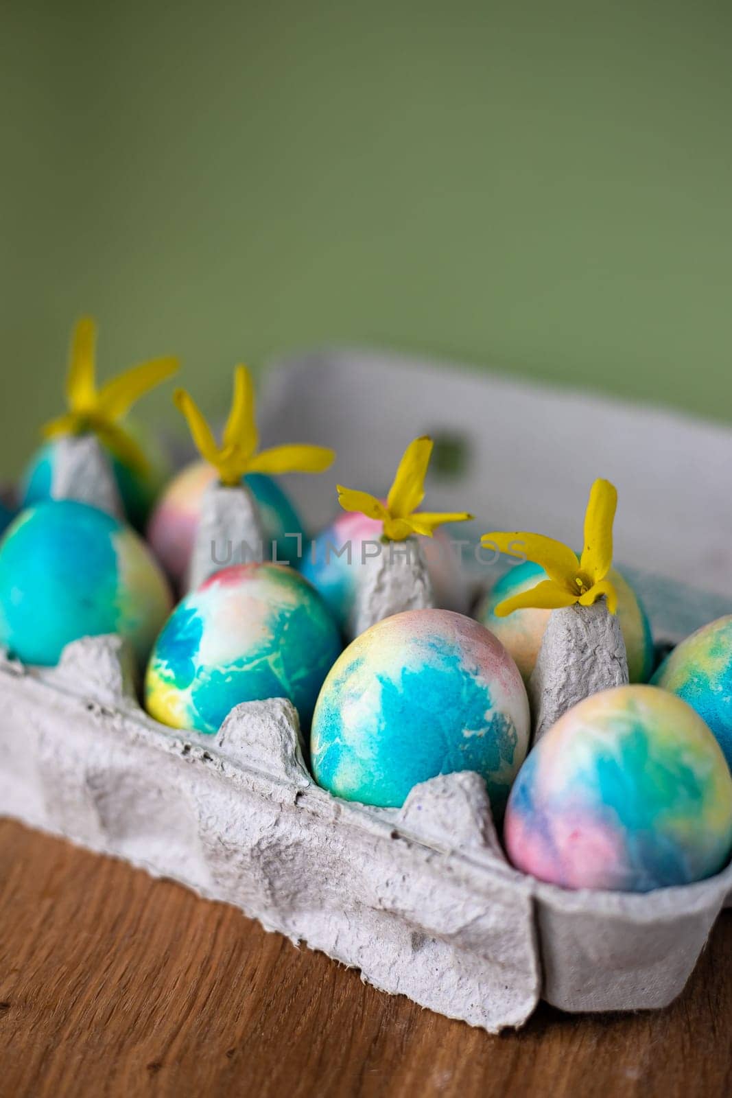 Easter composition with Easter cakes, wooden stand and spring flowers on a yellow background. copy space.