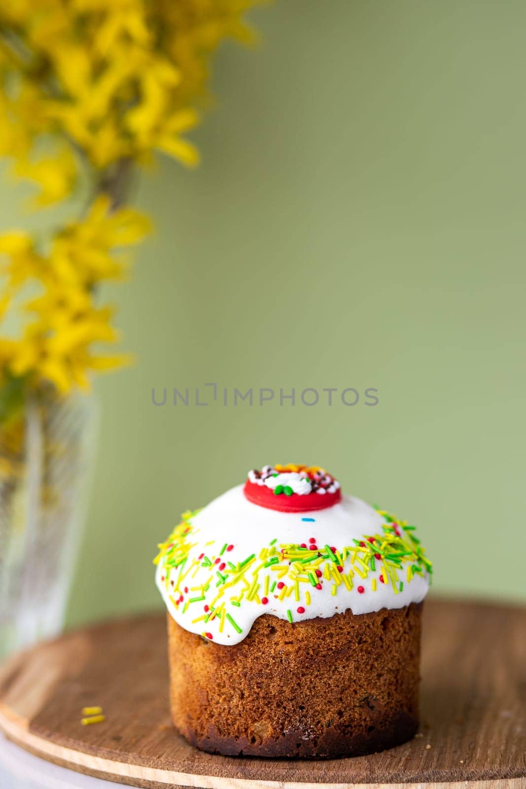 Easter cake with a bow on a yellow, light green background, and yellow spring flowers. Easter food. minimal concept by Anyatachka