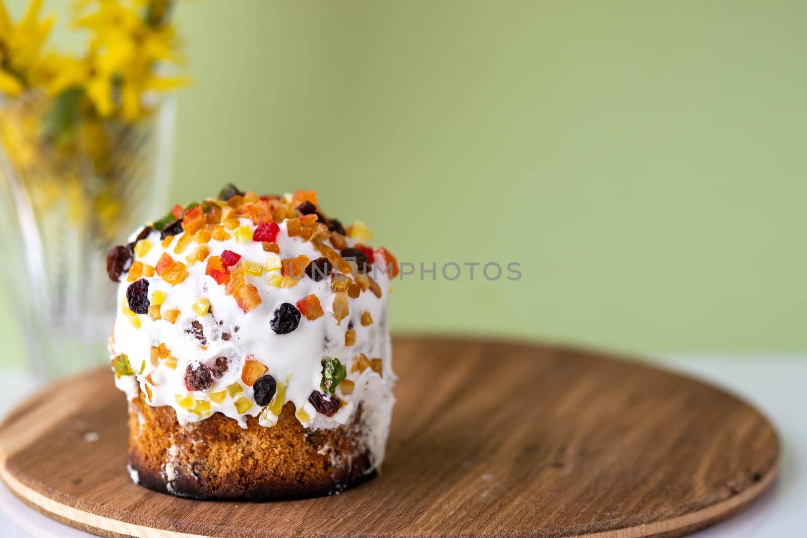 Easter cake with a bow on a yellow, light green background, and yellow spring flowers. Easter food. minimal concept by Anyatachka