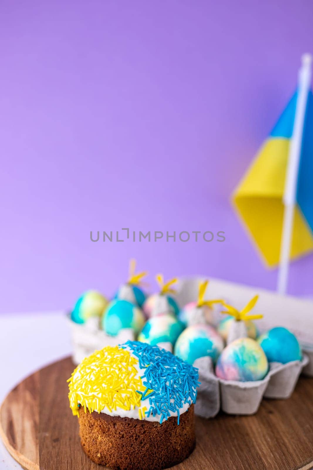 Easter cake decorated in colors of Ukrainian flag and eggs painted in yellow blue, laid out around it. easter concept, ukrainian traditions. Support Ukraine. by Anyatachka