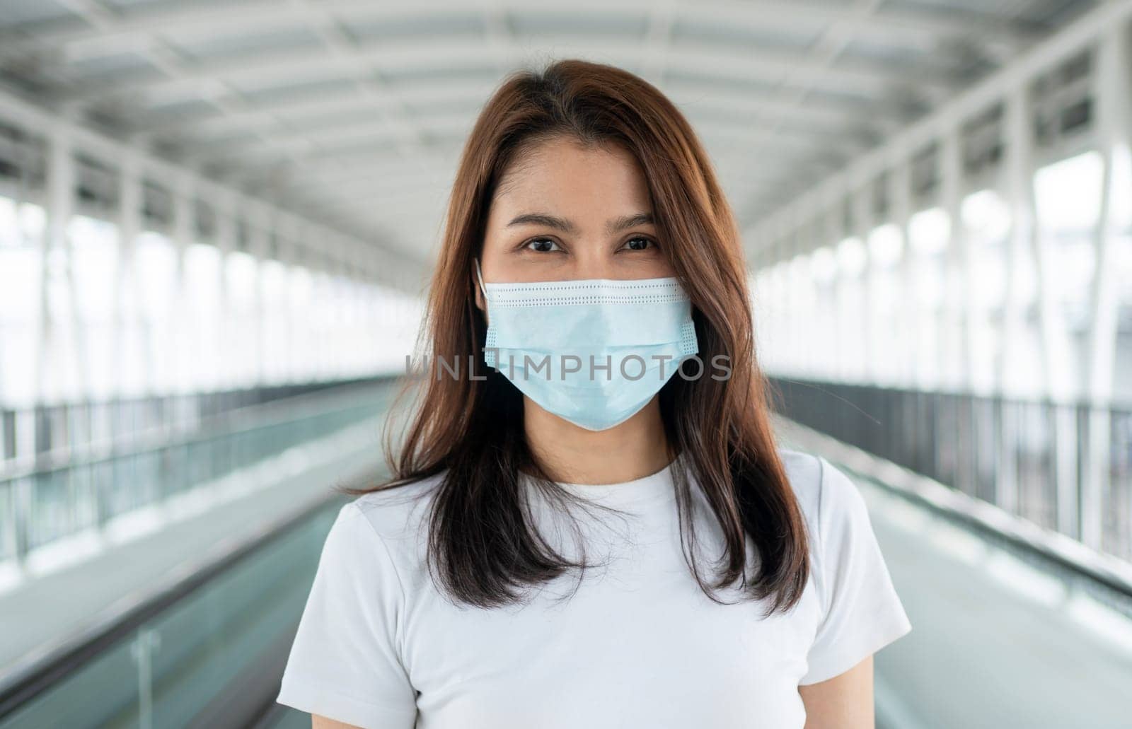 Portrait of a young woman in a medical mask for anti-coronavirus COVID-19 pandemic infectious disease outbreak protection in Public area. Concept of Virus pandemic and pollution (PM2.5) by PattyPhoto