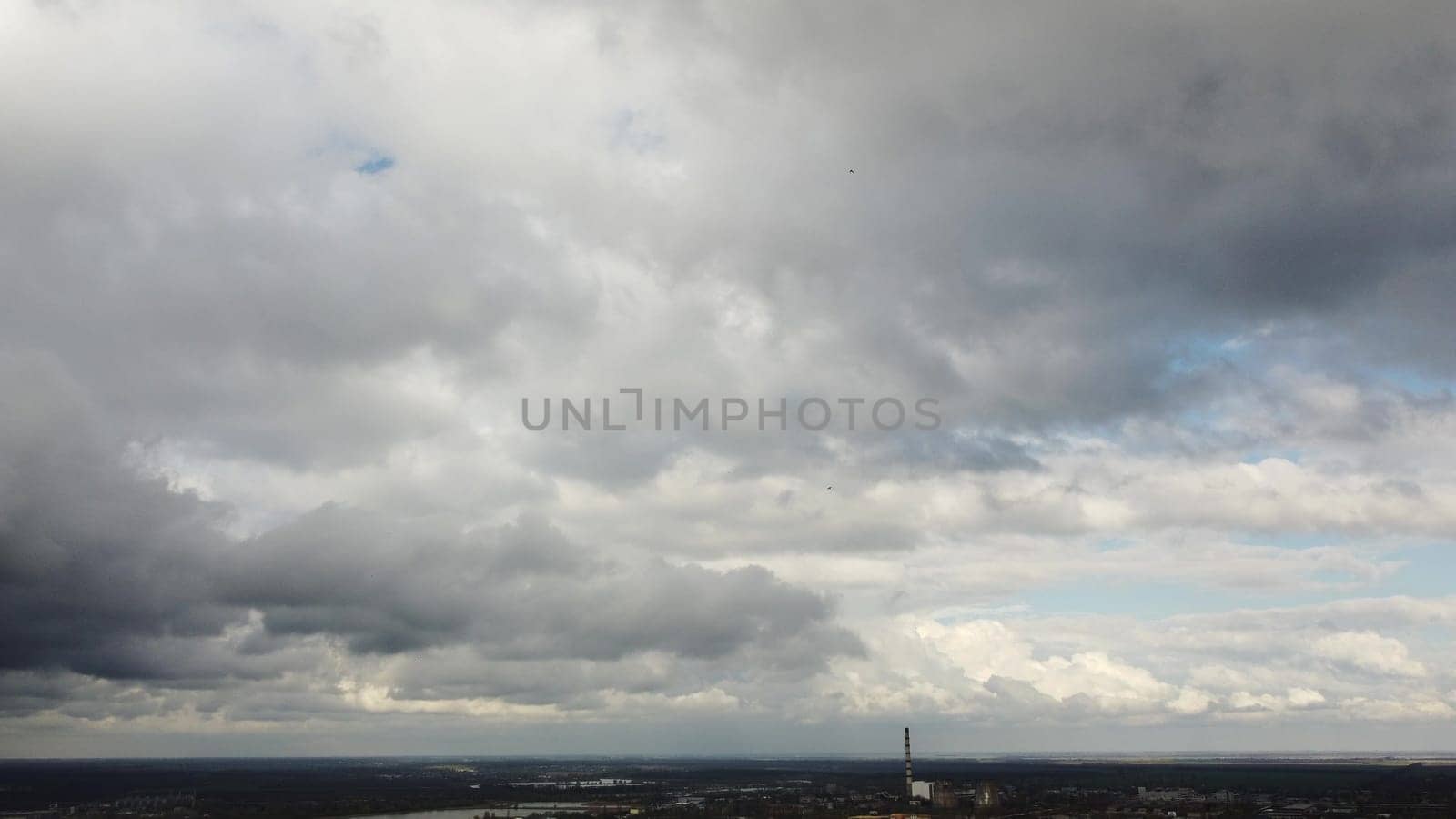 Movement of large dark rain clouds in sky. Big rain clouds move across sky. Aerial drone view. Panoramic natural background. Cloudscape scenic landscape backdrop. Rainy cloudy weather. Timelapse.