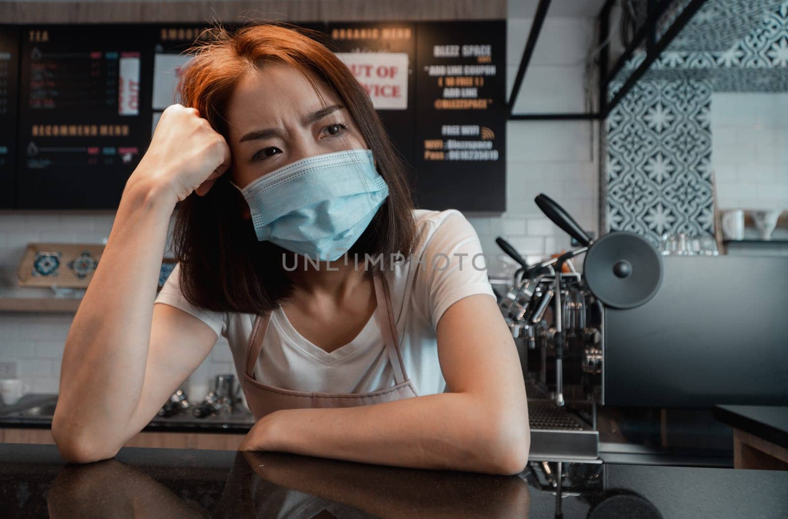 Asian woman coffee shop business owner Stressed and disappointed from The effects of the coronavirus pandemic resulting in business losses