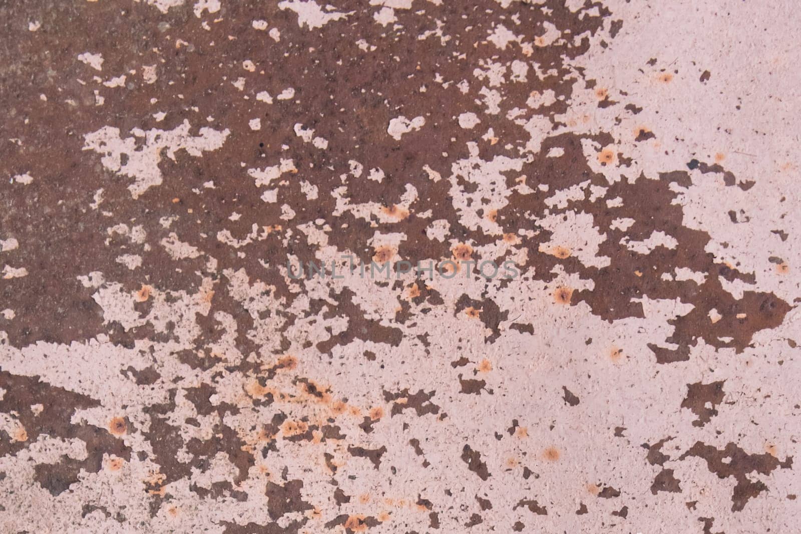 Light pink paint peeling off from the surface of the old metallic texture grunge steel background obsolete messy.