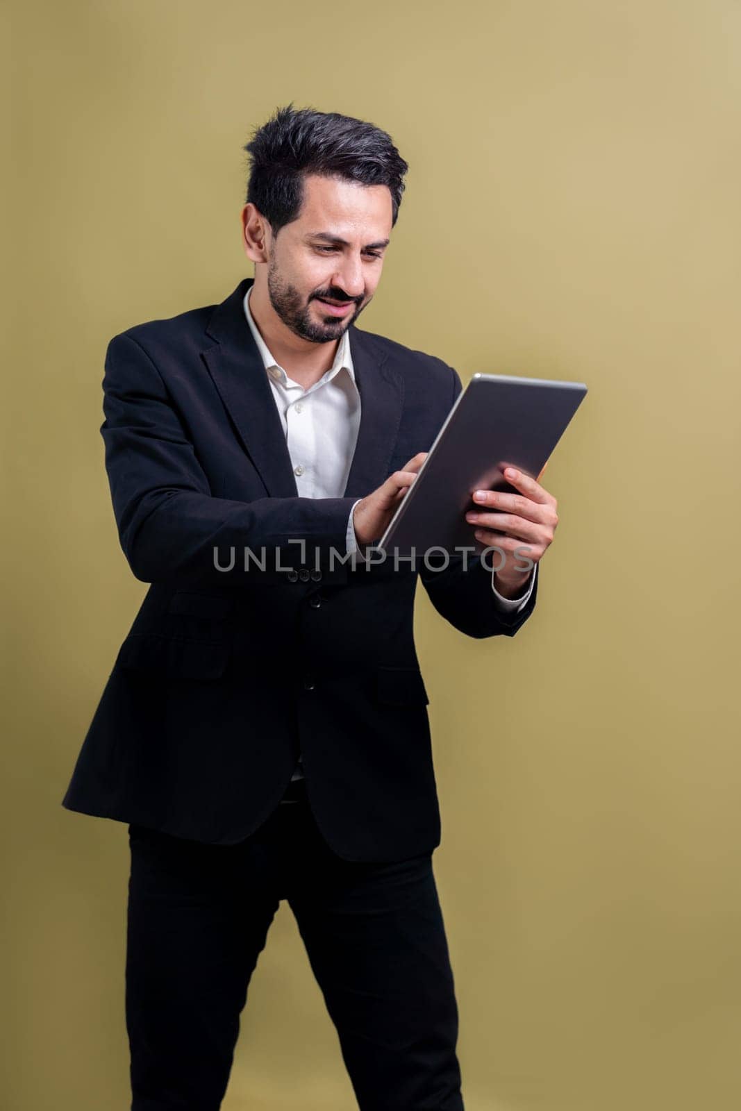 Confident businessman in formal suit holding tablet with surprise look. Fervent by biancoblue