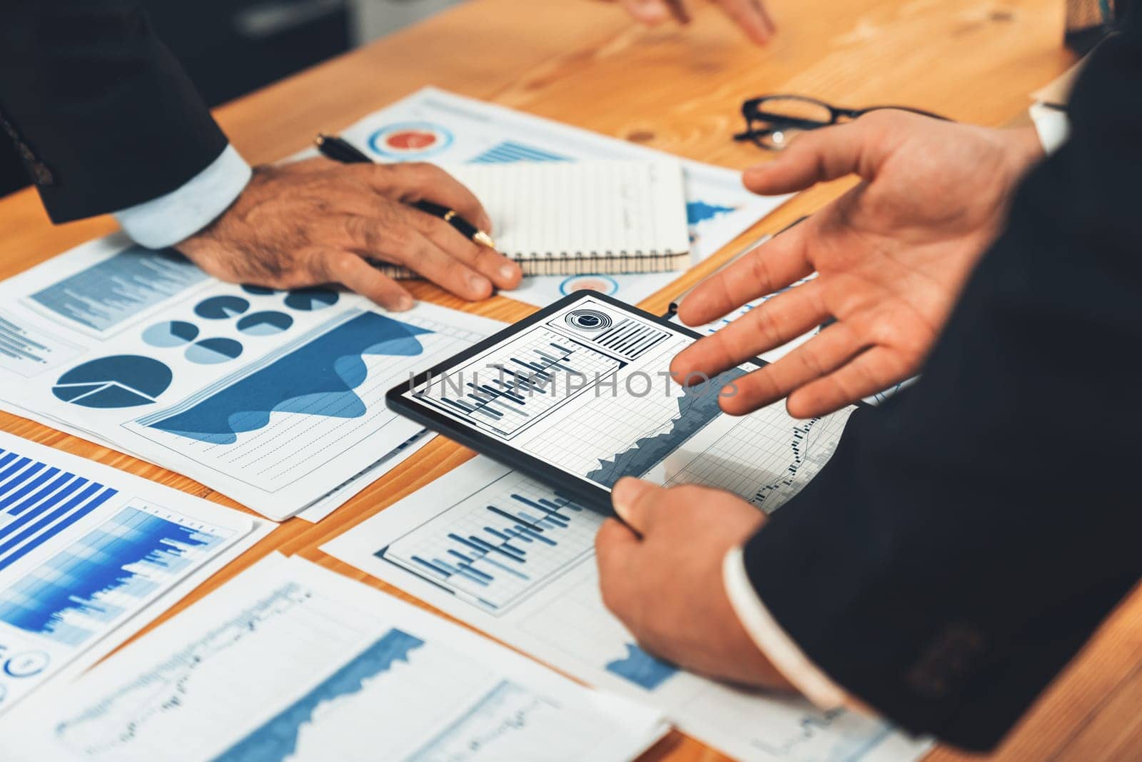 Closeup busy analyst team discussing financial data on digital dashboard, analyzing chart and graph using data science software display on a laptop screen. Business intelligence and Fintech. Fervent