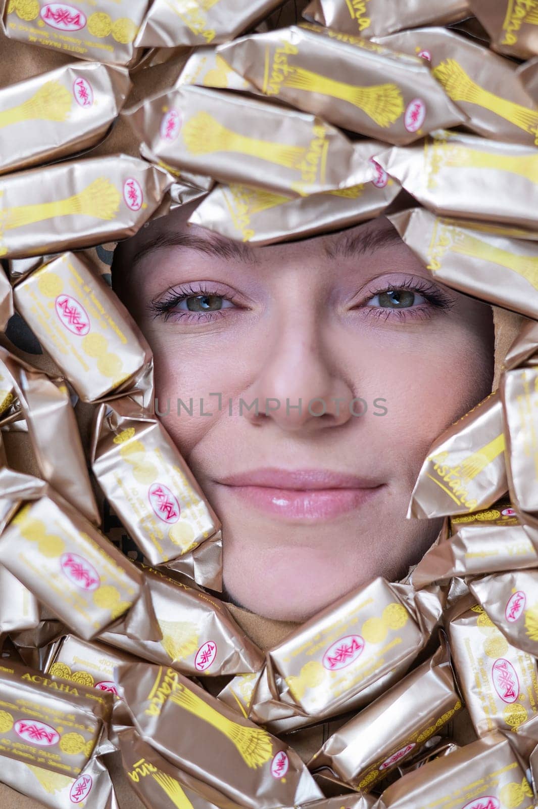 The face of a caucasian woman surrounded by Rakhat chocolates