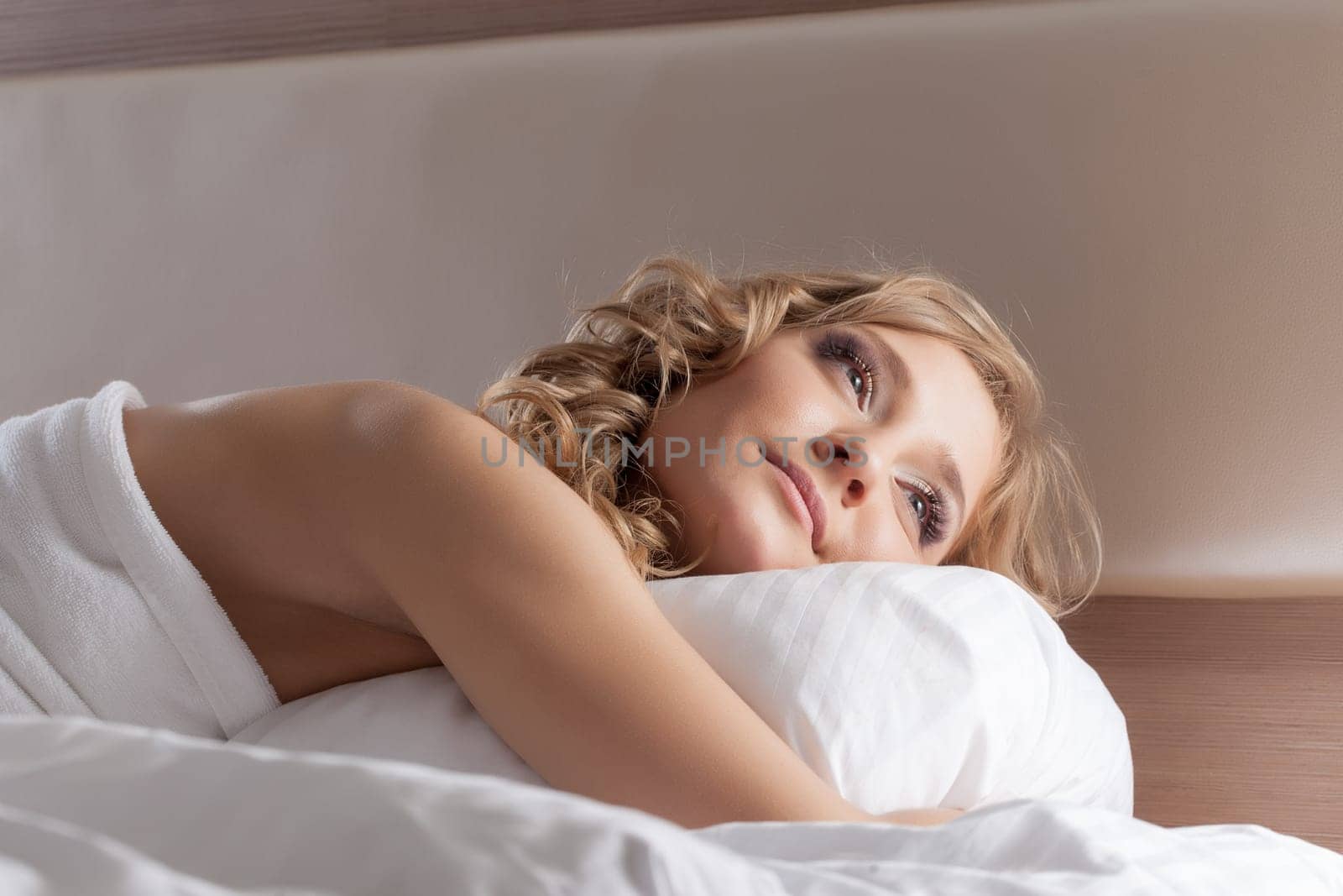 Portrait of lovely dreamy girl lying in bed, close-up