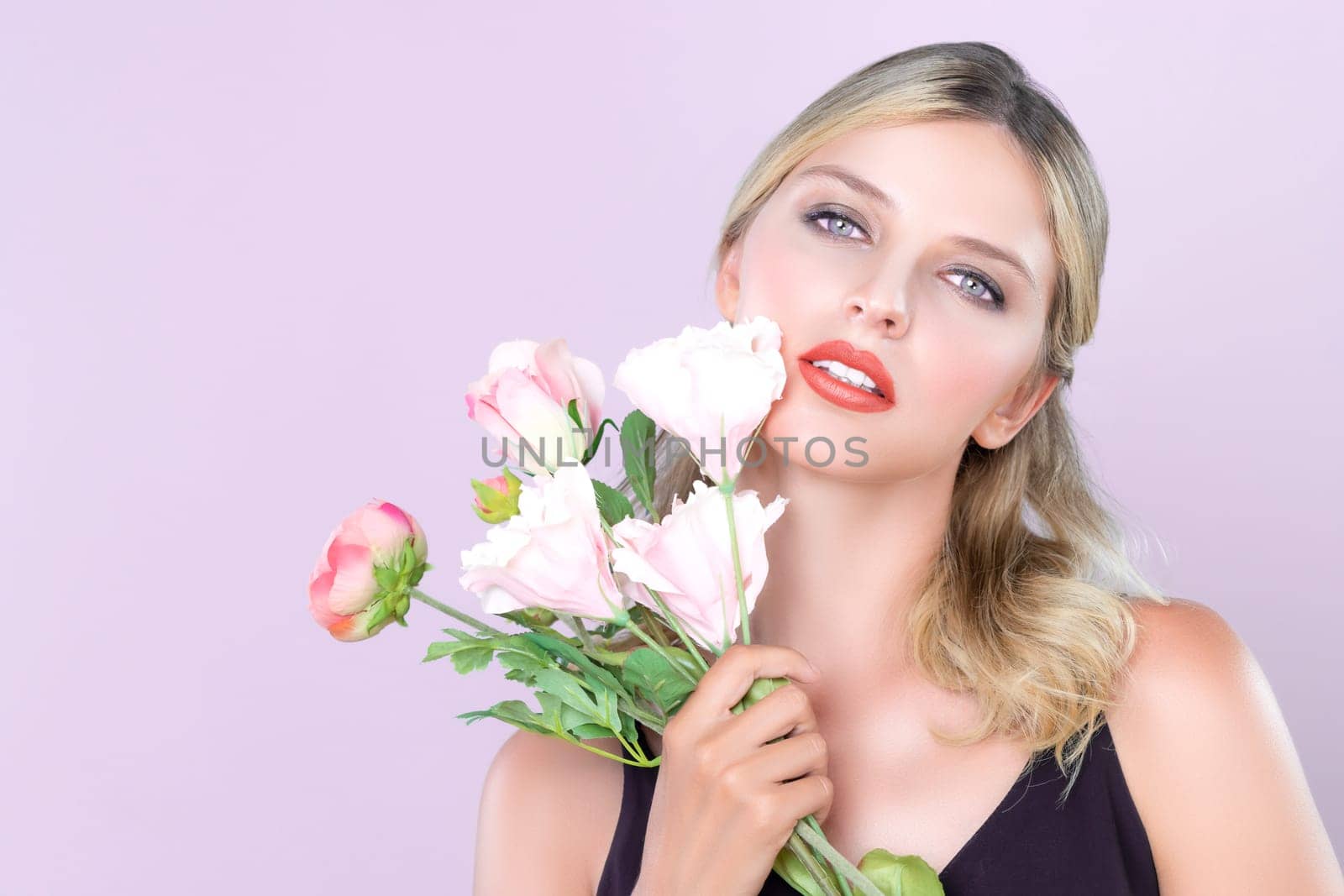 Closeup young woman with alluring flawless makeup and healthy skin holding rose for natural skincare treatment advertising in pink isolated background. Beautiful pretty model girl with flower concept.