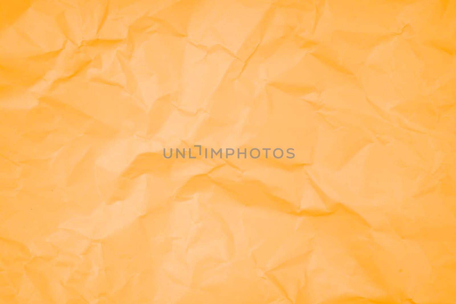 Abstract background from crumpled orange color paper texture.