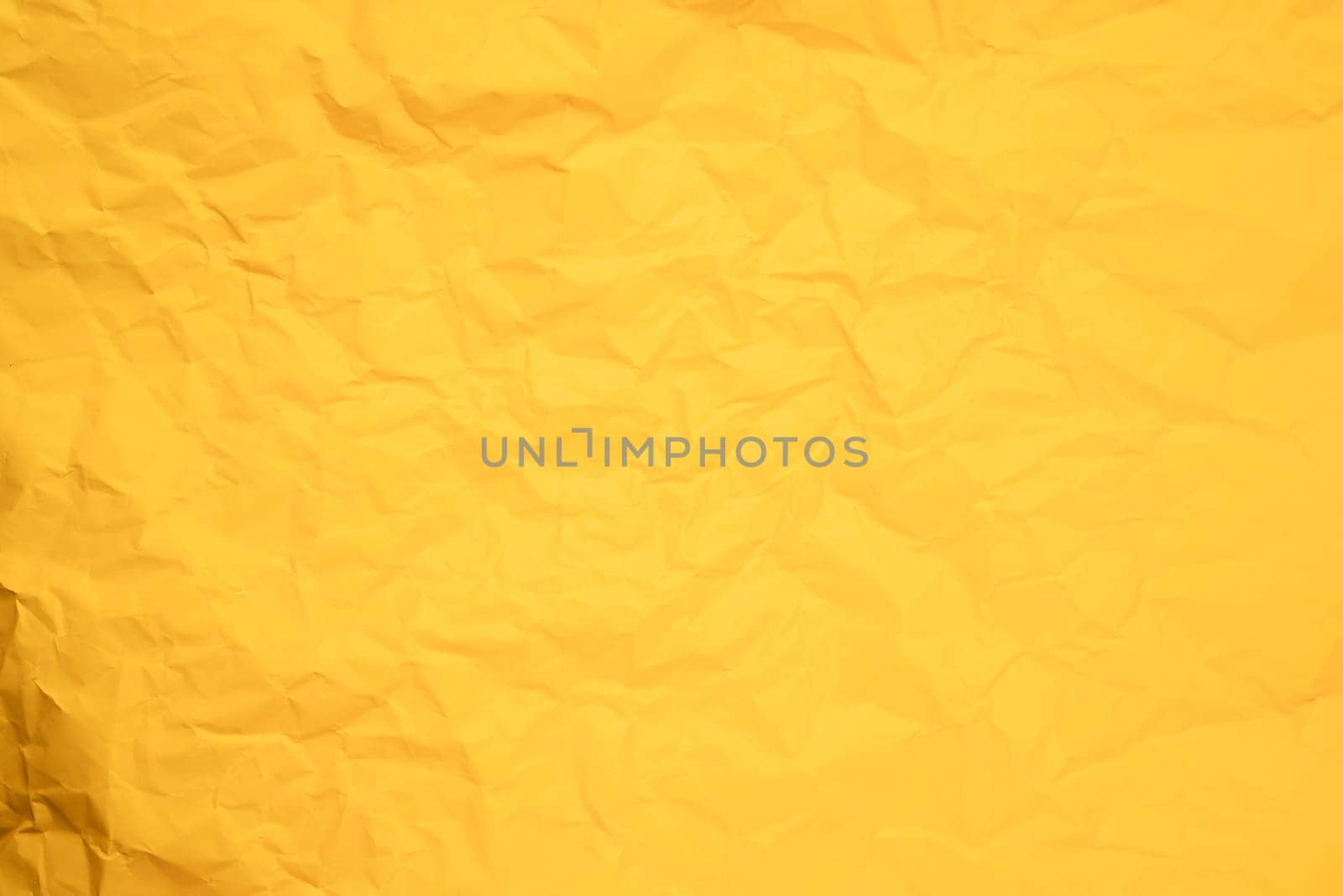Abstract background from crumpled yellow paper texture.