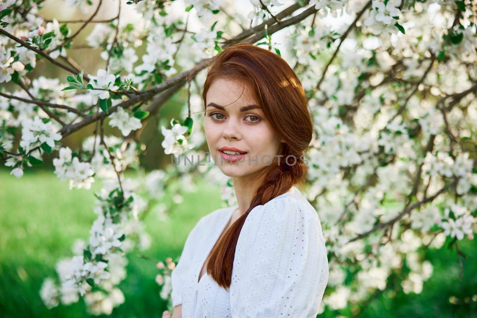 woman with flowers. gorgeous model in the spring garden. the girl near the tree in the spring. the concept of spring. young orchard by Vichizh