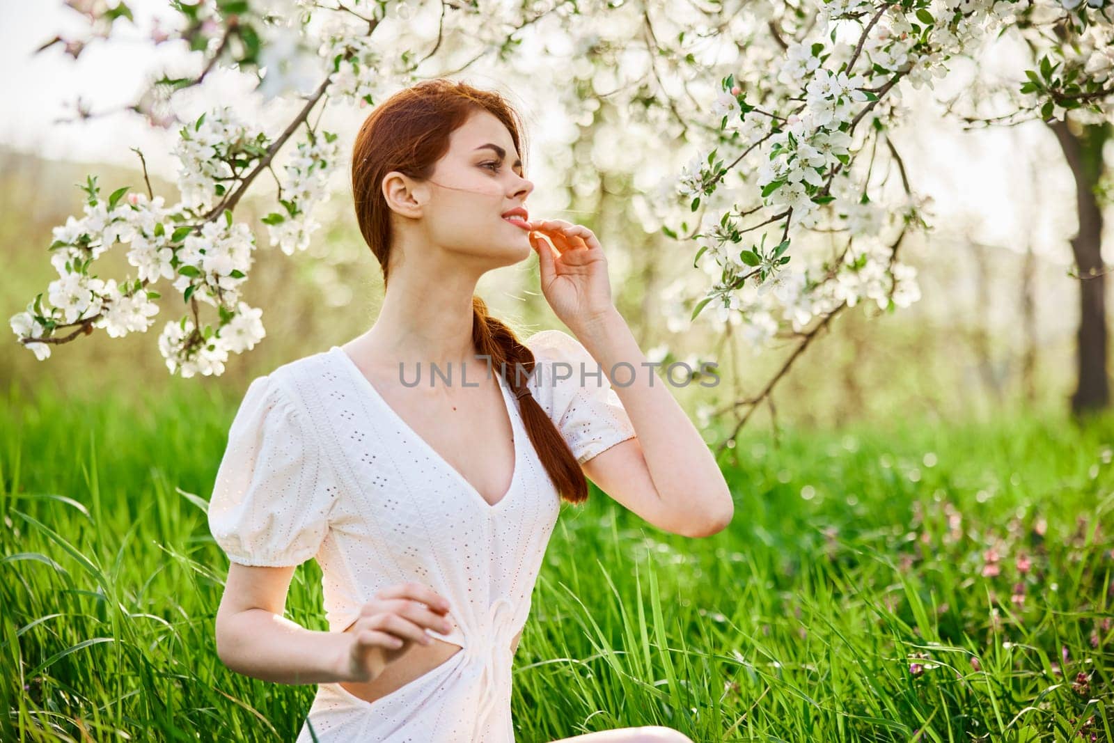 beautiful young readhead woman standing near the apple tree by Vichizh