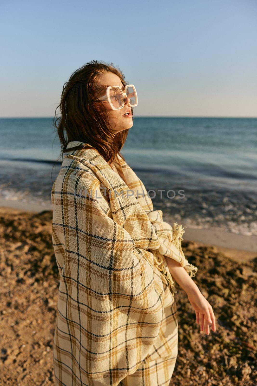 portrait of a woman with a plaid on a warm, sunny, summer day on the beach. High quality photo