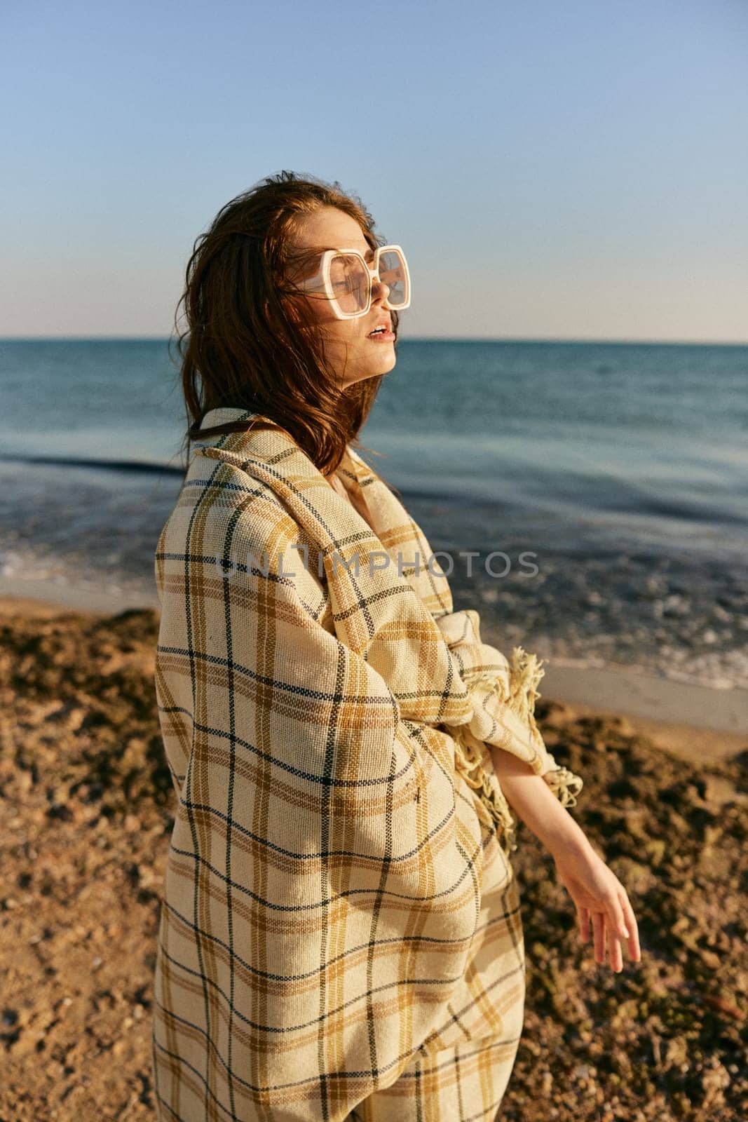 portrait of a woman with a plaid on a warm, sunny, summer day on the beach. High quality photo