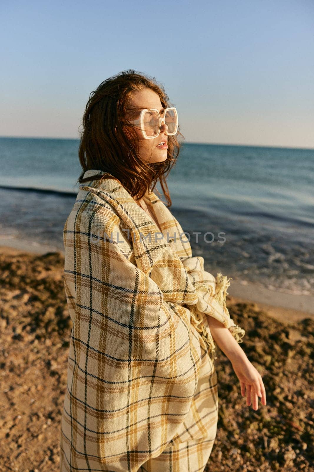 portrait of a woman with a plaid on a warm, sunny, summer day on the beach. High quality photo