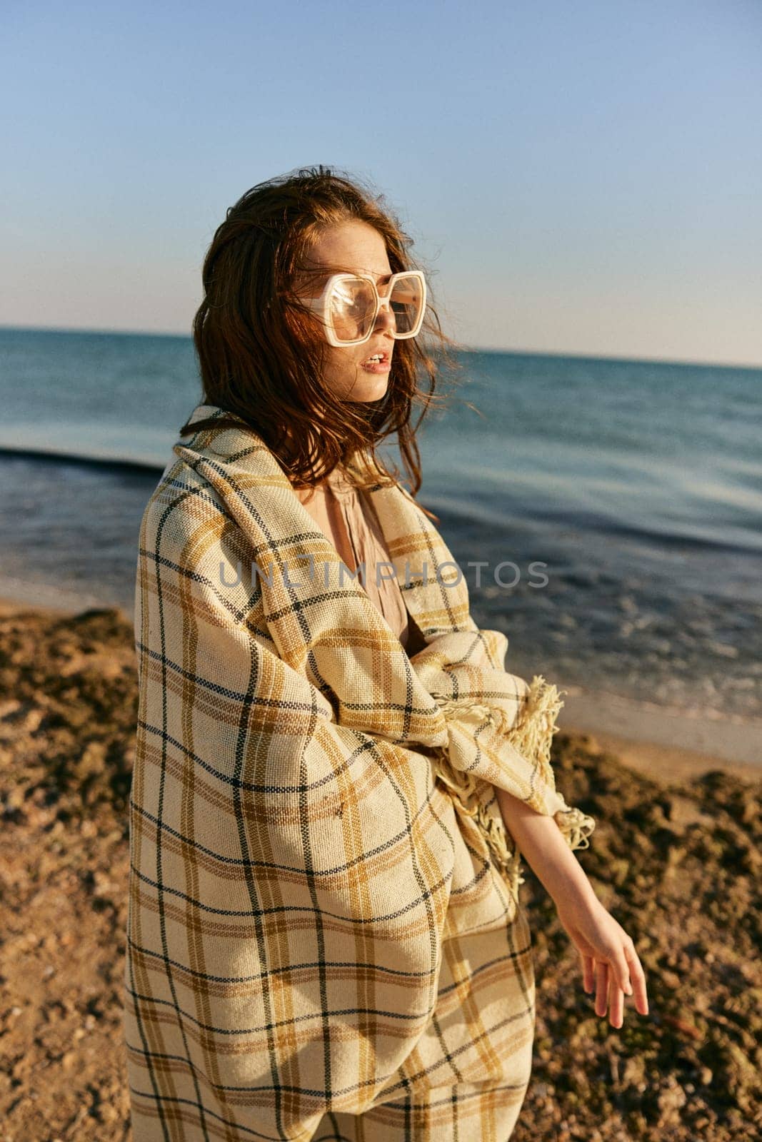 portrait of a woman with a plaid on a warm, sunny, summer day on the beach. High quality photo