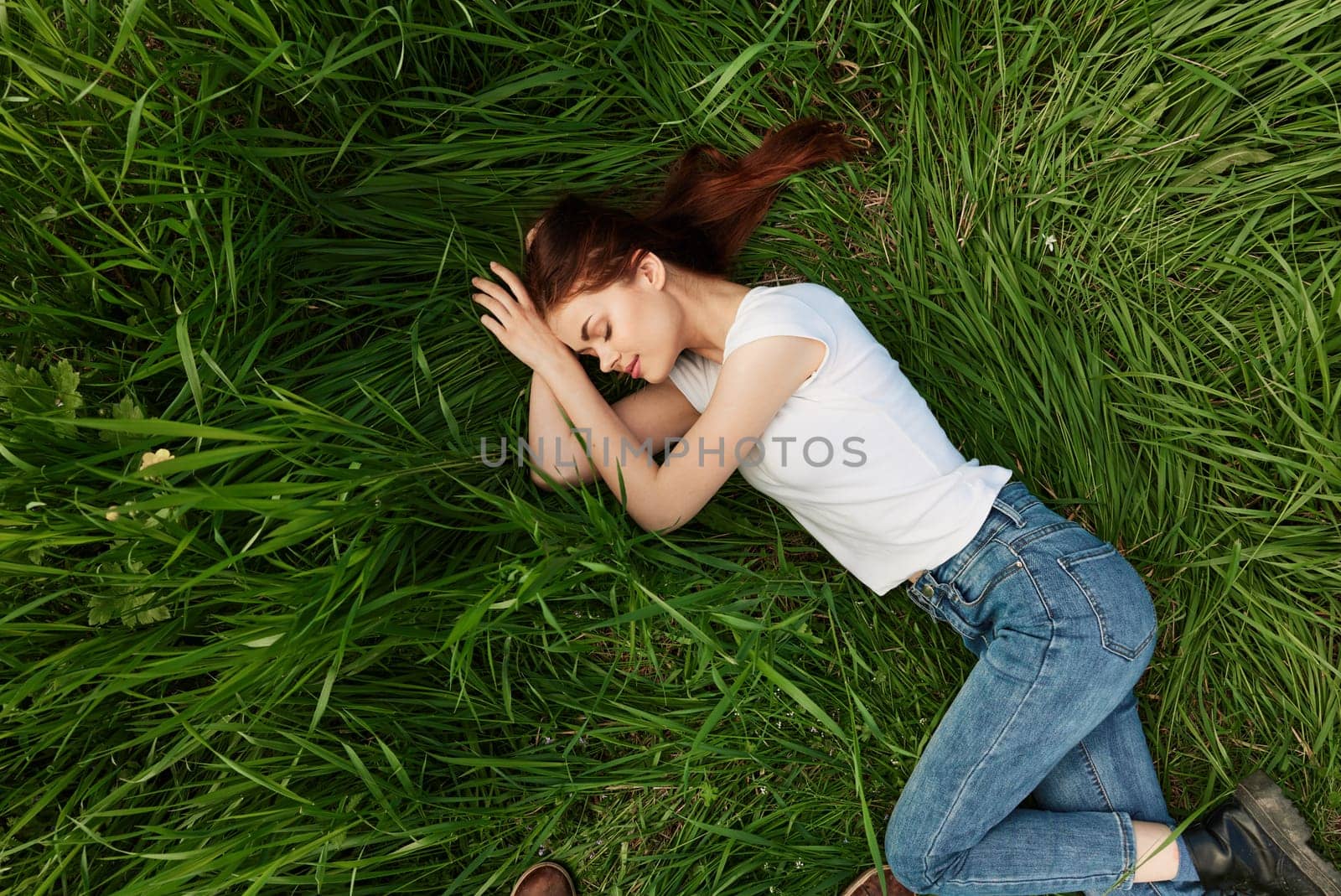 calm, peaceful woman falls asleep in tall grass. High quality photo