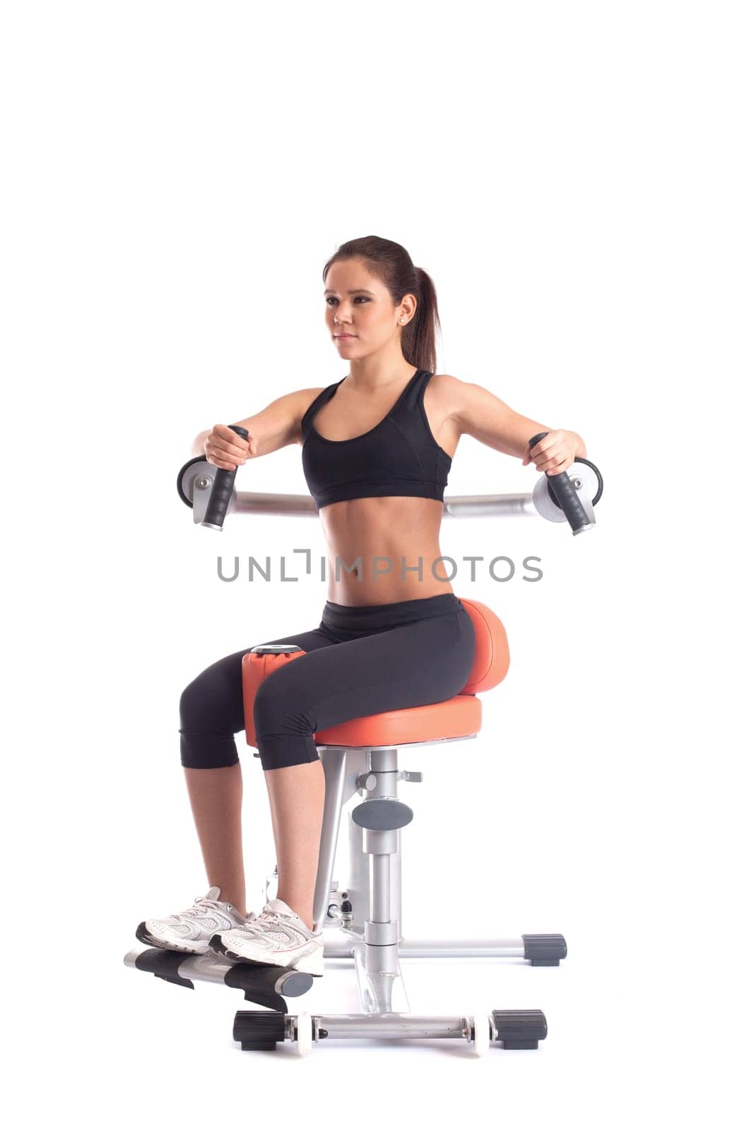 Pretty athletic girl exercising on isodynamic simulator